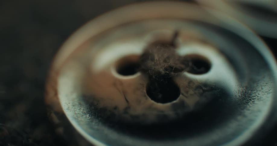 Closeup of a button attached to clothing with a thread