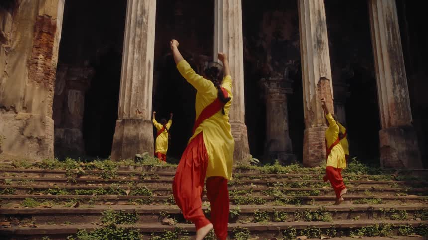 Four women dancing on the steps of an ancient temple