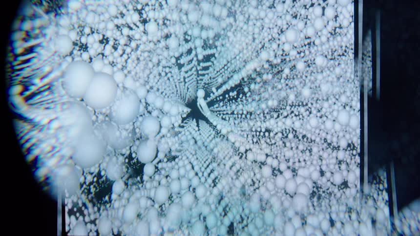 Opening allows a glimpse of white spheres forming patterns against a dark background