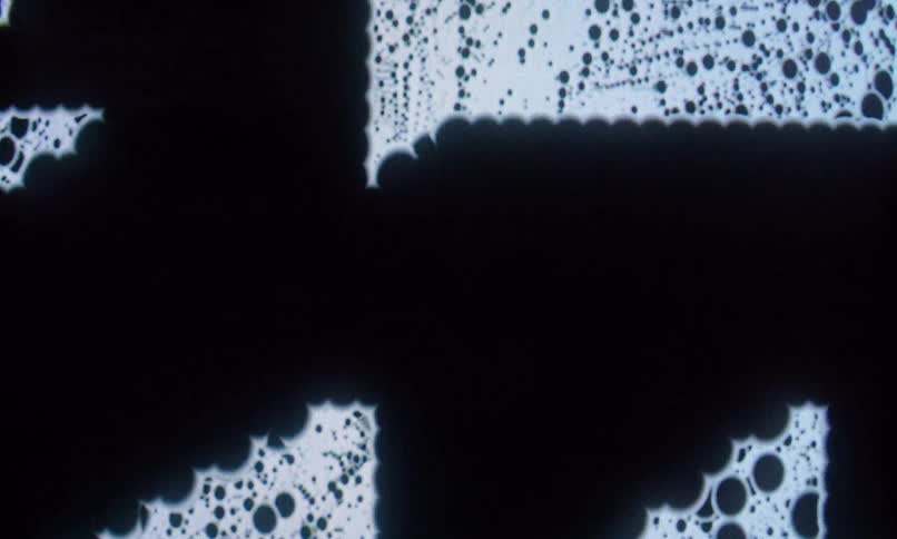 The dark orbs pass through the white graphic