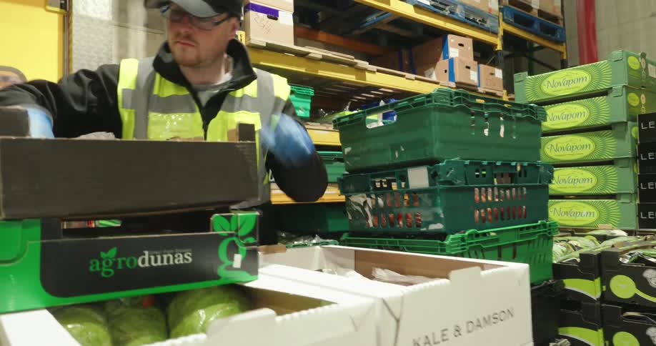 A worker fills a box in the warehouse