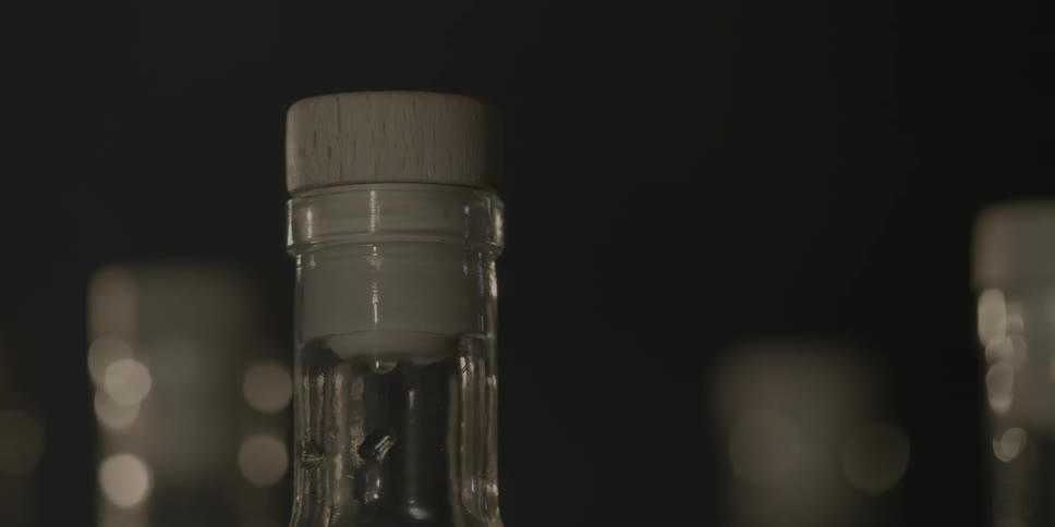 A cork sits in a bottle, while lights blink in the background
