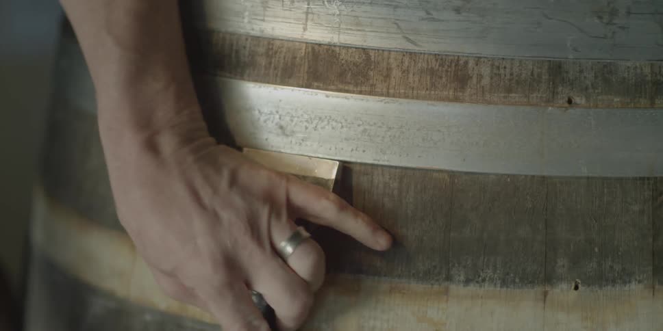 A man knocks a barrel ring out of place