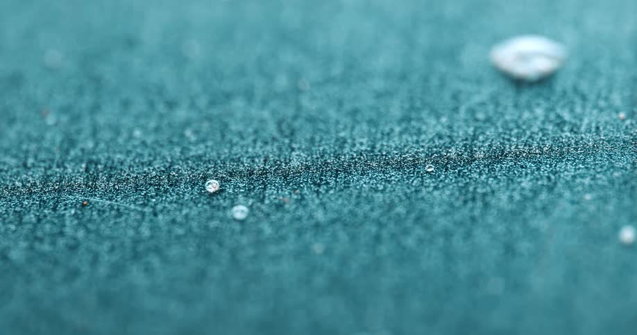 Rain drops splashing on blue fabric