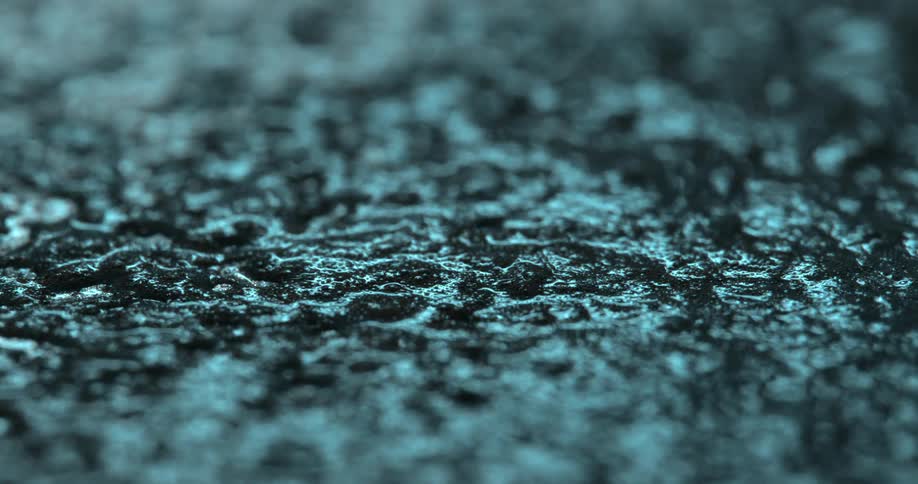 Extreme close up of rain falling on wet asphalt