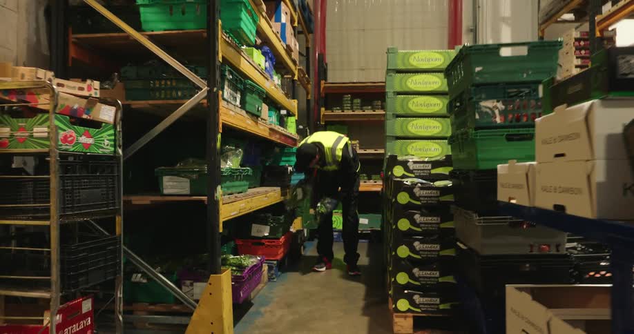 Man taking products from a warehouse and placing them on a table for counting