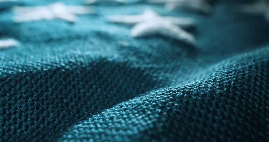 Close up of a fabric with white stars on a blue background