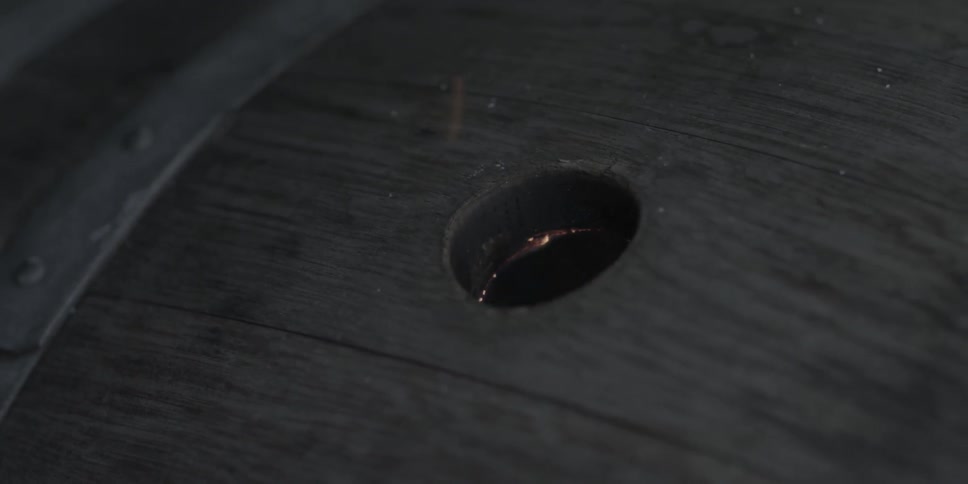 A flame burns through a hole in a barrel