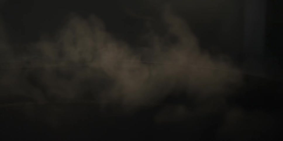 Smoke slowly rises in a dark room