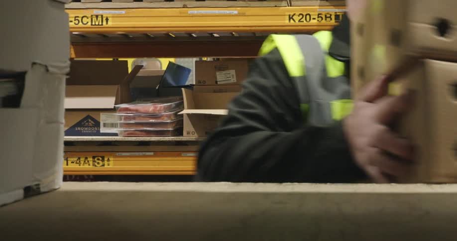 Man taking a box from a shelf and carrying it