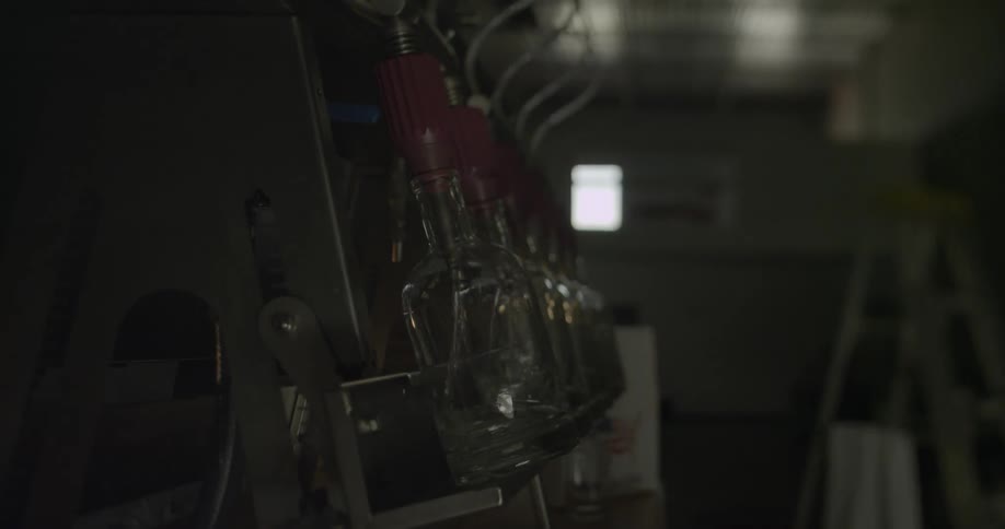 A man adjusts a bottle that is being filled