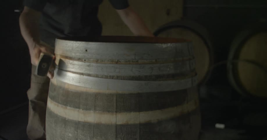 A man removes a metal ring from a barrel