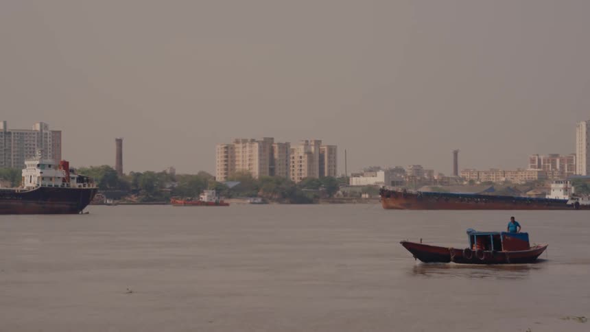 Ships cruise through the water outside of a city