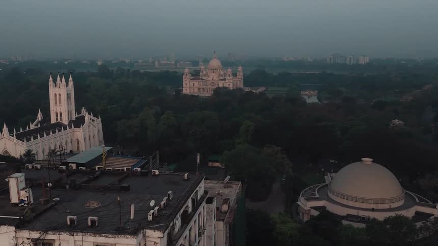 Aerial view of a city building followed by a gothic church next to a domed building heading to a palace