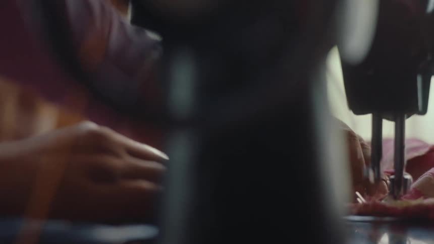 Close up of a tailor sewing using a manual sewing machine