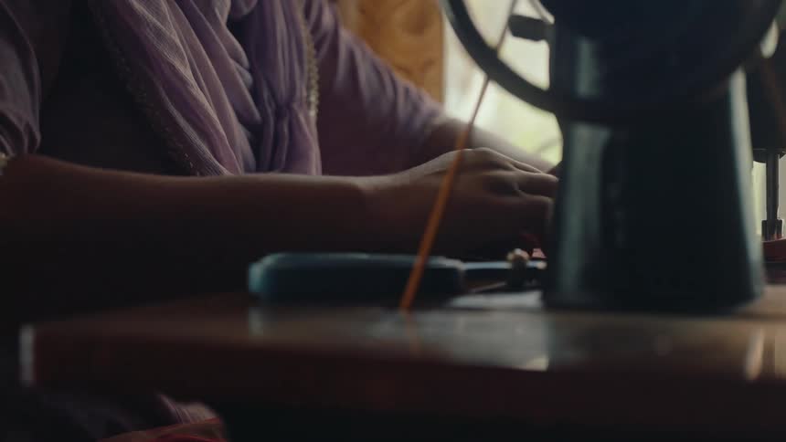 Woman sewing on a vintage manual sewing maching