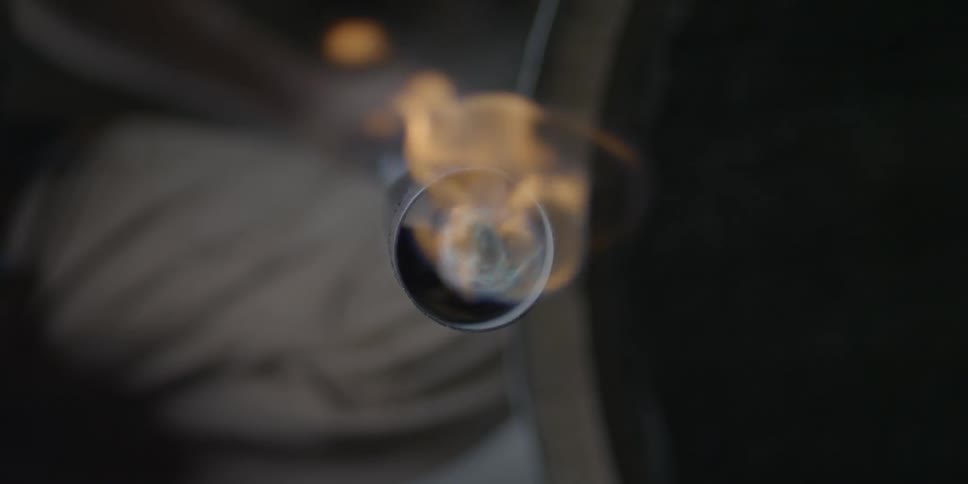A man ignites a fire on a metal torch
