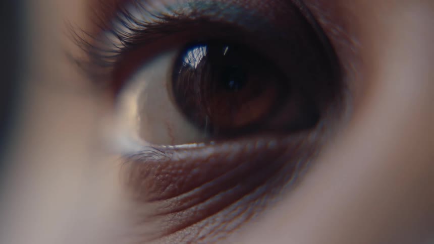A persons closed eye with its eyelid painted black and then they open their eye and their iris is brown