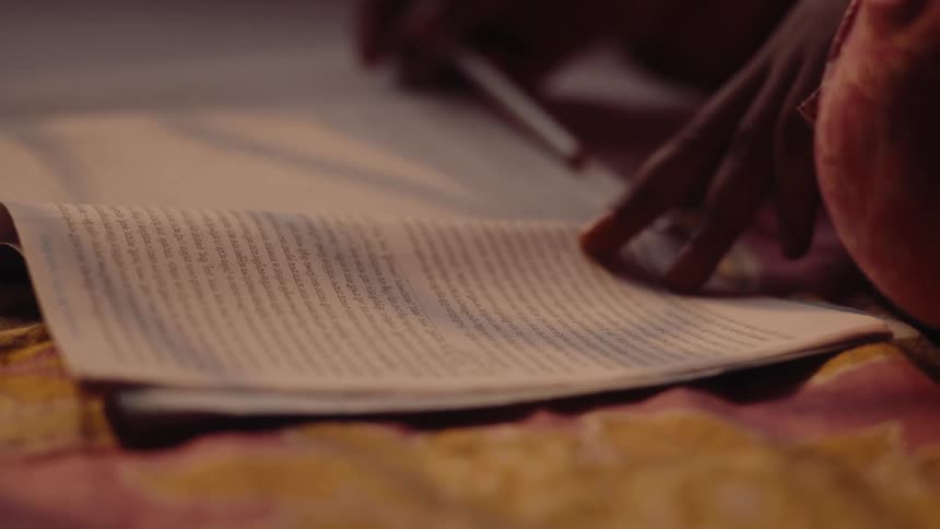 A child sitting on a rug on the floor reading a book