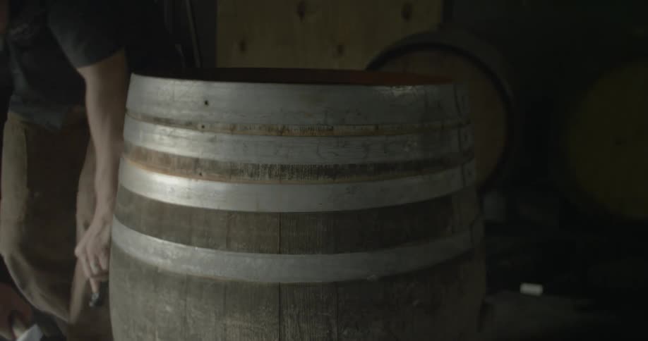 A man is hammers a ring on a barrel off