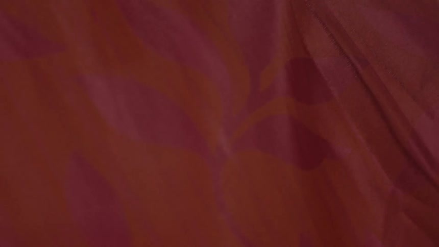 Close up of orange fabric with pink flowers