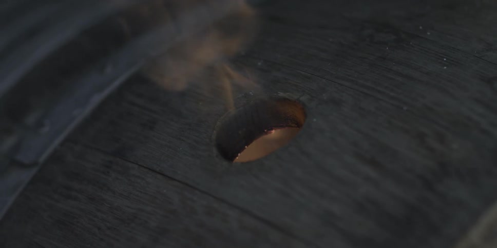 Fire shoots through a hole in a barrel