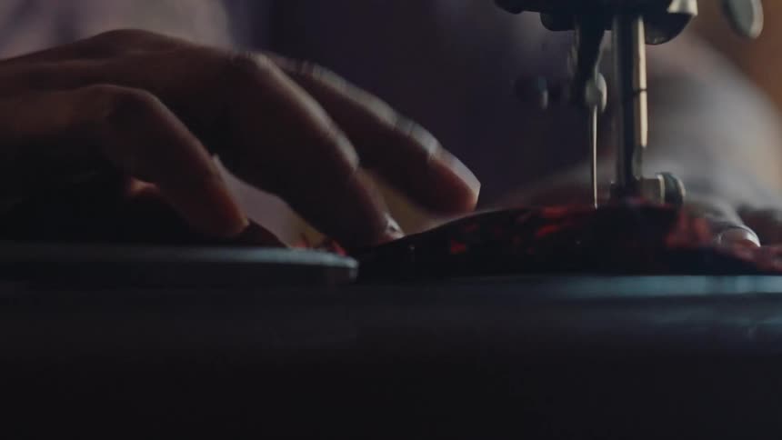 A person sewing fabric on a sewing machine