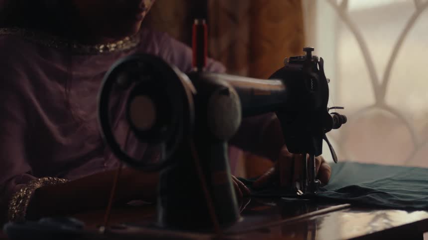 Woman sitting sewing clothes