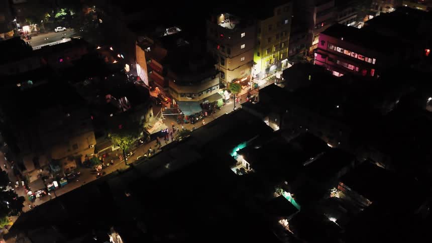 Aerial of buildings and a busy street in a city at night