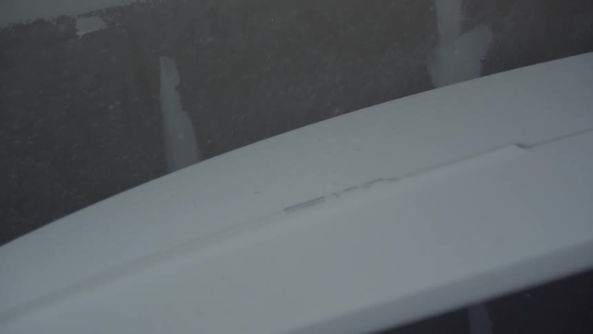 A person is using a device to shave a surfboard