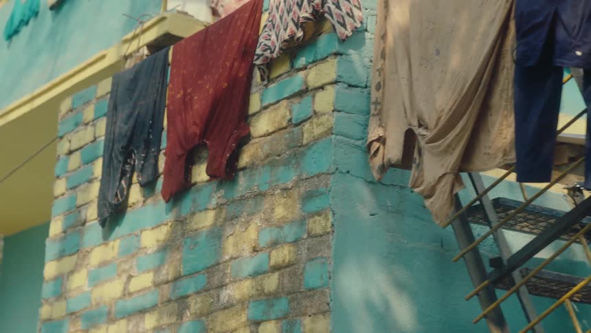 Clothes hang on a clothes line and on the building
