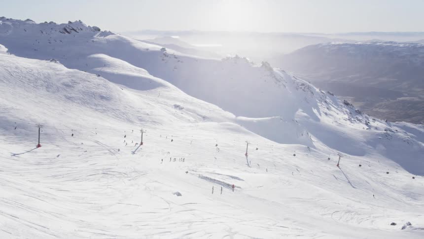 Skiers descend a snowy mountain