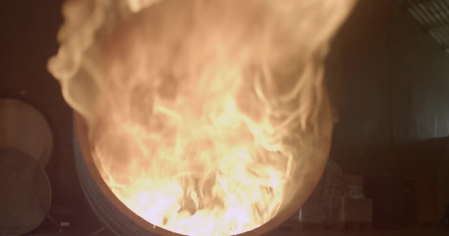 A torch is removed from the flames burning in a barrel