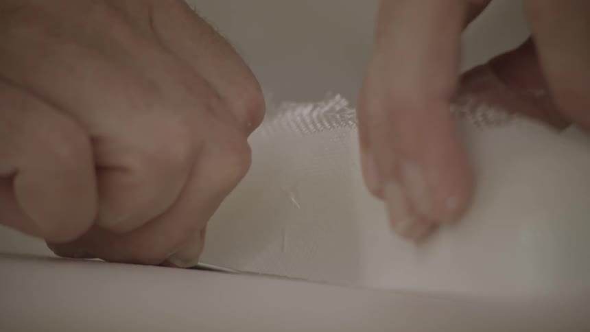 Two hands crease a piece of paper