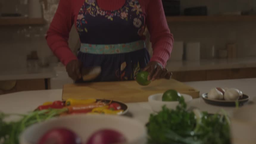 Woman describes and demonstrates a vegetable cutting process in the kitchen