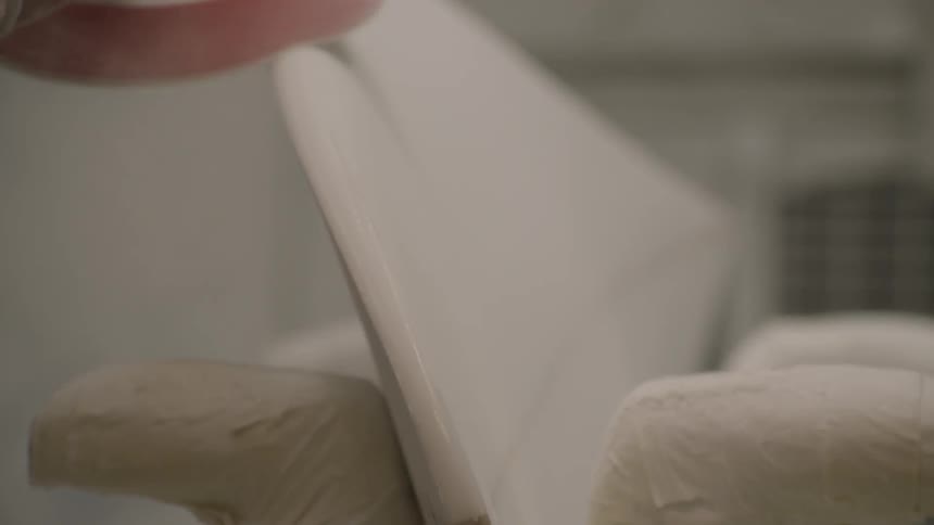 A surfboard is being sanded on its edges