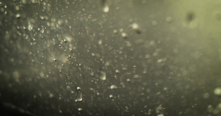 Water swirls and large bubbles flow and flit about chaotically bumping into each other and spreading out as the camera pans to the right