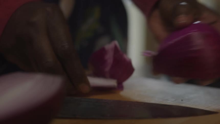 A woman cuts and peels an onion