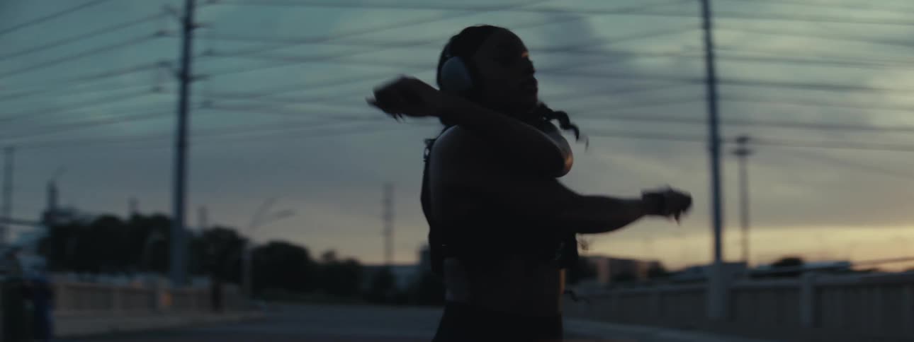 Silhouette of a woman outdoors stretching her arms