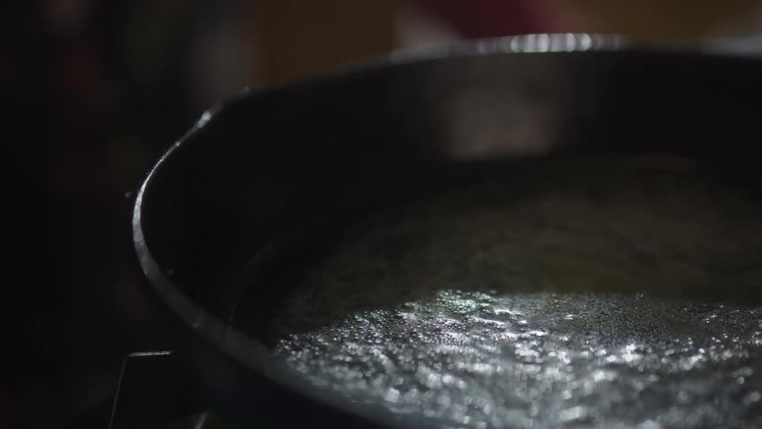 Woman talking while adding butter to a skillet and stirring