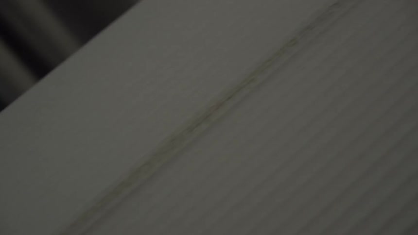 A white, unfinished surfboard is shown