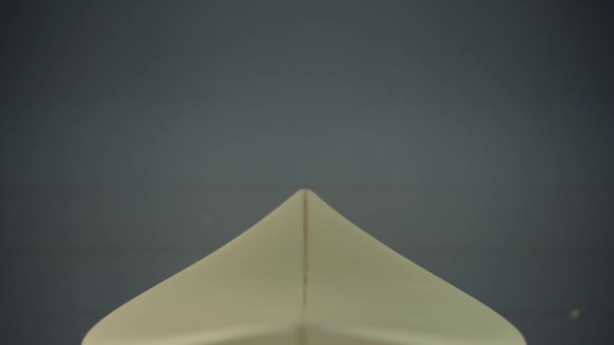 An unfinished surfboard sits in a platform