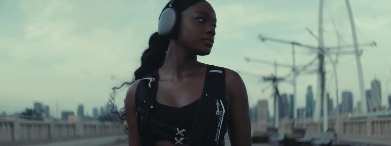 A female athlete is warming up before running on a bridge near downtown