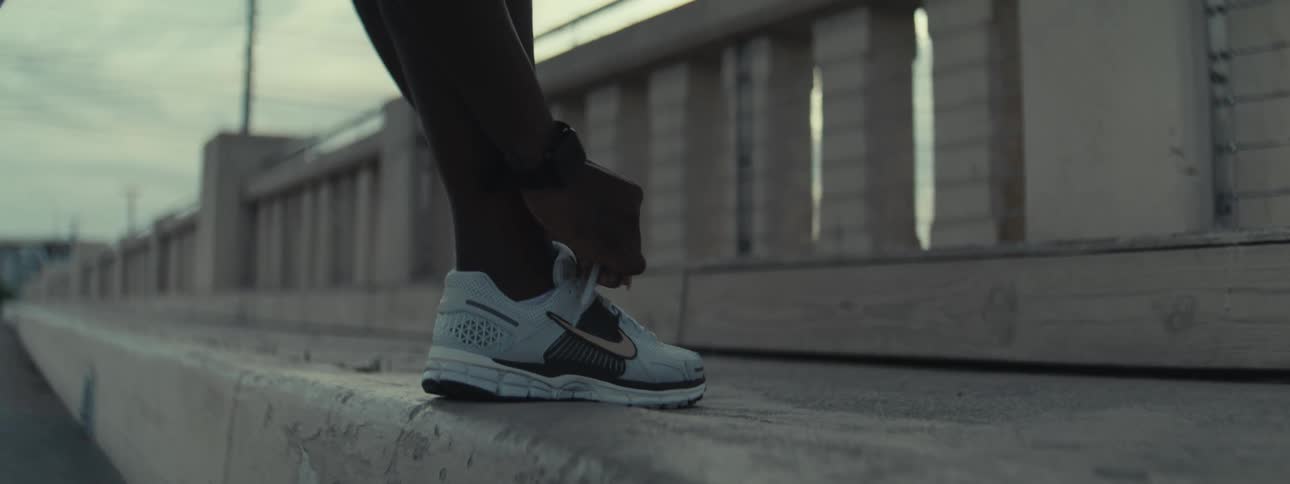 Pair of hands tying the laces of white sneakers