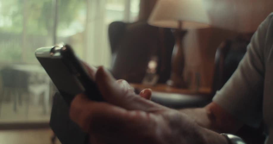 A footage of an elderly man operating a smartphone