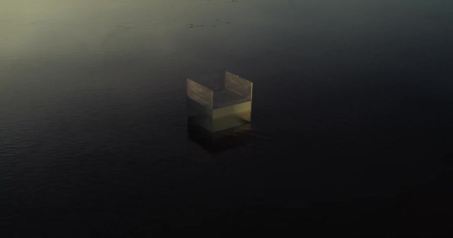Transparent box with water inside on a shallow water surface