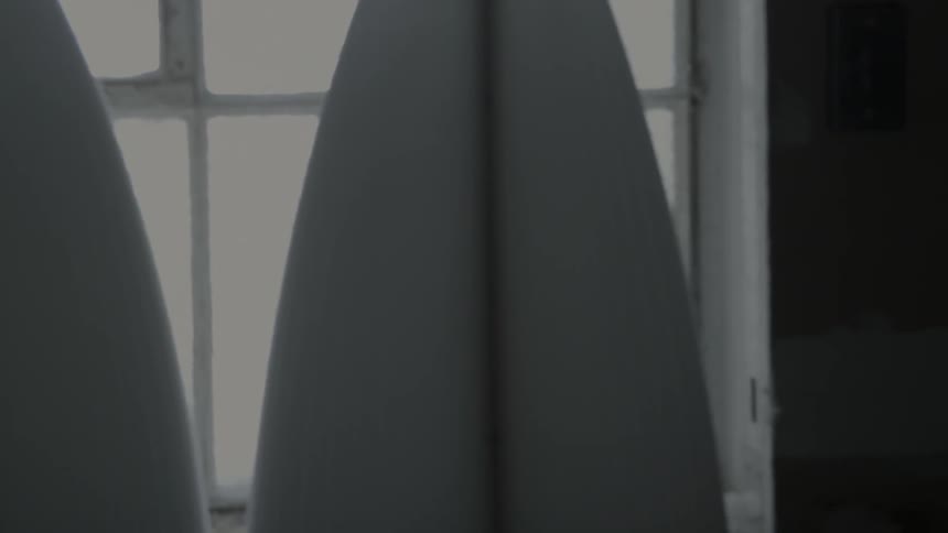 Surfboards stand in front of a window