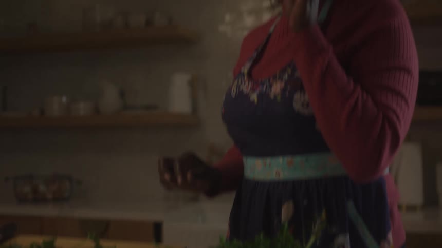A woman talks and then begins cutting up vegetables