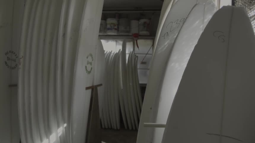 Surfboard forms are stacked against the wall