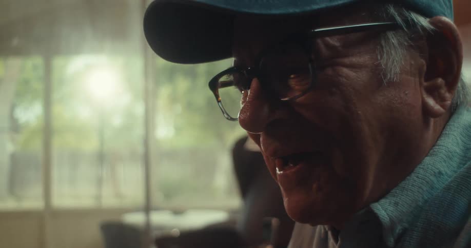Elderly man in cap watching and cheering